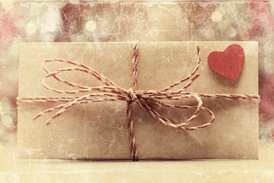 Envelope with bow and red heart. Valentines day concept. Old photo stylized image