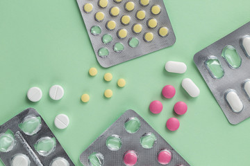 Pharmacy drugs, tablets in packages on a simple green background, painkillers and other medical...