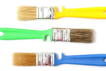 Colored paint brushes with plastic handles on a white background, isolate, flat layer, close-up.