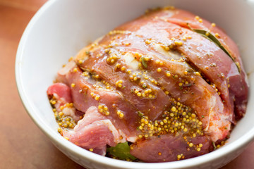 Marinating meat with spices and mustard on table. Selective focus, horizontal image