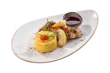Baked rabbit leg with pear and mashed potatoes on white plate isolated on white background