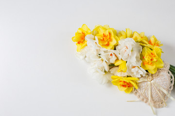 on a white background a bouquet of daffodils and a heart of lace