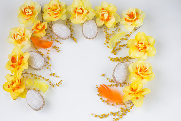 the arch is lined with yellow daffodils and mimosa, feathers and eggs from fabric