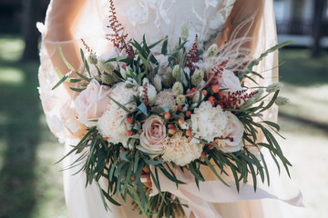 beautiful wedding bouquet with red, pink and white flowers, roses and eucalyptus, peonies, calla...