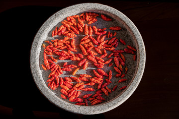 Fototapeta premium Dried small red chilies in a stone bowl