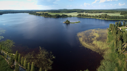 Aerial view of blue lake and green forests on a sunny summer day. Bird's eye view drone photography. Ruovesi, Finland.