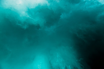 Wave with bubbles underwater. Transparent blue ocean in underwater