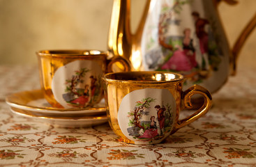 Old soviet gilded porcelain teapot and two cups.