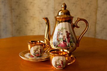 Gilded porcelain teapot and two cups.
