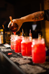 Close-up of expert bartender making cocktail in bar.