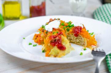 Homemade cabbage rolls with carrots, red tomato sauce and cream on a white plate