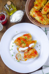 Homemade cabbage rolls with carrots, red tomato sauce and cream on a white plate