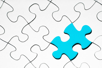 Obraz premium Light blue puzzle piece in between of white puzzle pieces