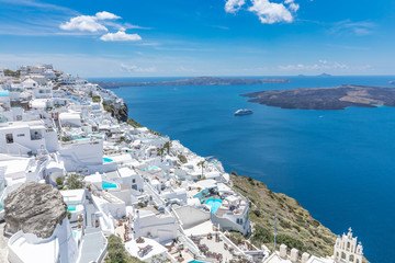  Santorini, Greece. Famous view of traditional white architecture Santorini landscape with flowers in foreground. Summer vacations background. Luxury travel tourism concept. Amazing summer destination