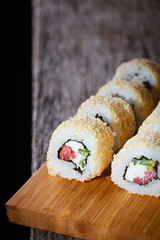 Sushi roll sushi with prawn, avocado, cream cheese, sesame.