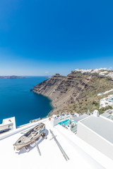 Fototapeta na wymiar Santorini, Greece. Famous view of traditional white architecture Santorini landscape with flowers in foreground. Summer vacations background. Luxury travel tourism concept. Amazing summer destination