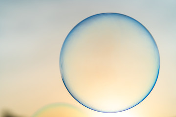 Floating bubbles against sunset scape.