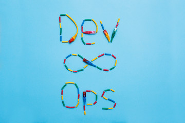 Devops concept. Developers and operations words made from cables and symbols on the blue background. Space for your text.
