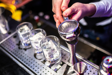 Expert bartender making cocktail at the bar. Squeezes juice, splash of juice