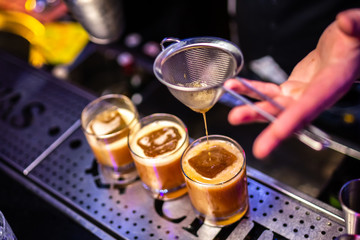 Fototapeta na wymiar Expert bartender making cocktail at the bar