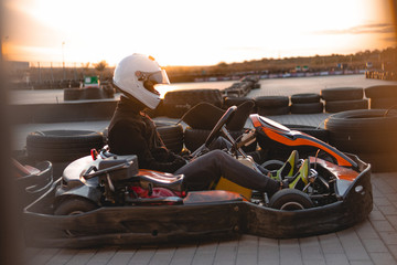 A driver in gear and helmet drives a racing car. In action. Go karts racing, sreet, rent. extreme...