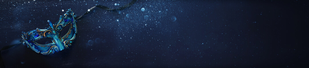 Fototapeta premium Photo of elegant and delicate blue Venetian mask over dark wooden background