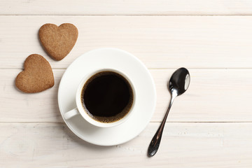 Delicious homemade cookie hearts with a cup of coffee on a wooden background. Top view. Place for text.