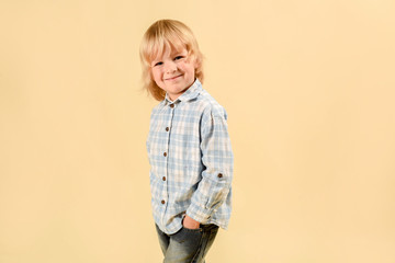 Funny child.fashionable little boy in a plaid shirt and jeans .fashion children In the studio on a light background.