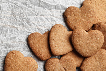Delicious homemade cookie hearts on parchment paper. Top view. Place for text.