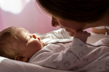 Beautiful closeup of mother and newborn baby on soft background. Happy spring day. Health care. Family, newborn. Happy childhood. Love card.