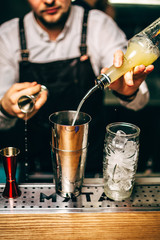 Close-up of expert bartender making cocktail in bar