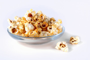 Popcorn in a transparent glass plate on a white background