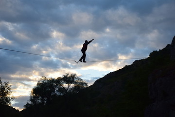 Practicing highline sports between rocky mountains, walking on a thin line