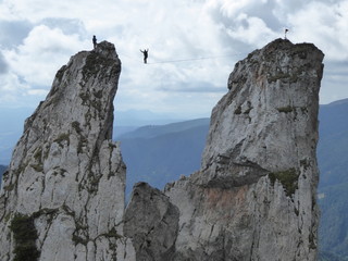 Practicing highline sports between rocky mountains, walking on a thin line