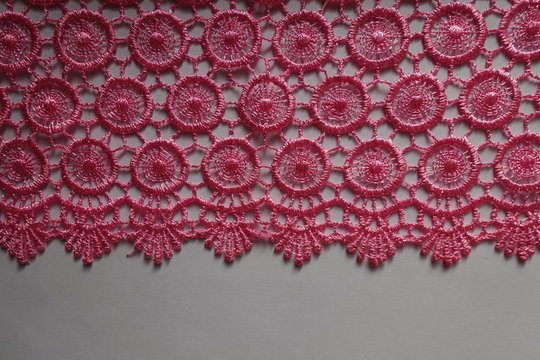Horizontal edge of bright pink crochet lace