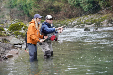 young woman learning to fly fishing with a guide
