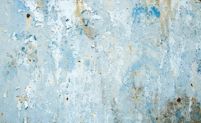 Old distressed grungy wall with blue peeling pint