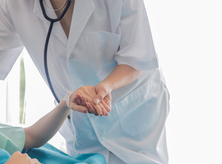 Asian female patient lay on the bed of a patient in a hospital waiting to see a doctor. Female doctors shook hands to encourage patients. Health care concept