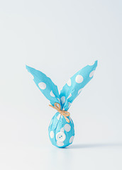 Easter background. Easter egg wrapped in wrapping paper and shaped like an Easter bunny