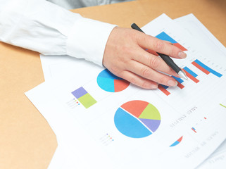 woman hand with pen and business report. Accounting