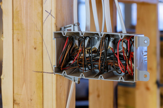 Interior view of a electrical box with wiring in a new home under construction wooden beams