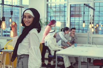 Young arabian muslim woman in hijab black clothes hold in hand holding bitcoin. Cryptocurrency exchange