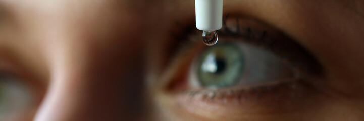 Female putting liquid drops in her eye solving vision problem