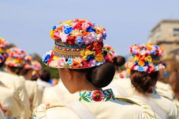 Girls in trendy romantic hats with colorful flowers stand at the city festival, carnival. Ukrainian...
