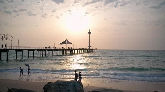 Brighton beach, adelaide south australia, people at beach in slow motion at sunset
