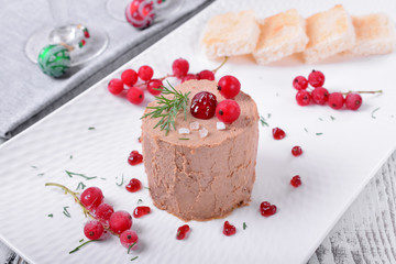 Foie gras garnished with berry sauce and sea salt on the white plate