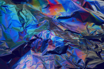 Holographic iridescent crumpled foil texture background