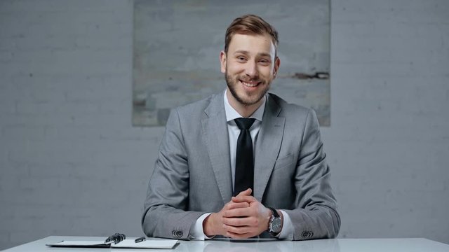 positive businessman talking while looking at camera
