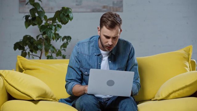 upset man making online bets on laptop at home