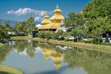 Yellow temple reflected in the lake in northern Thailand